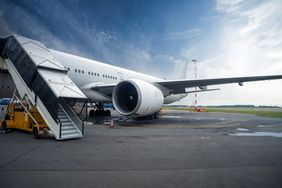 Commercial airplane on the airfield docked with passenger ladder