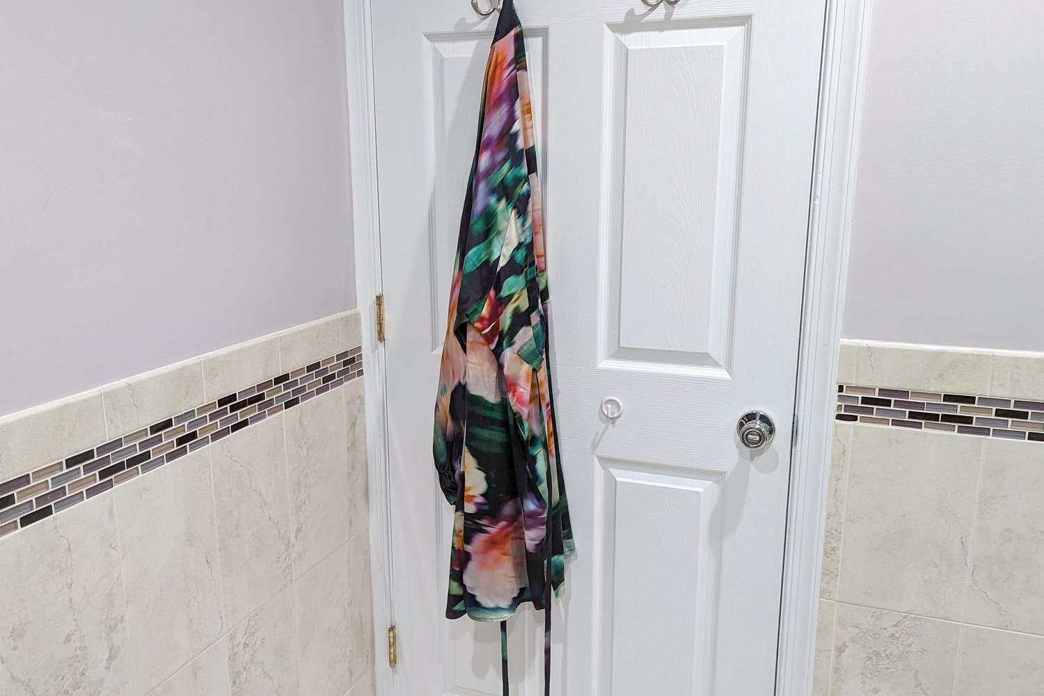 Colorful Lunya Washable Silk Robe hanging on a hook on a door