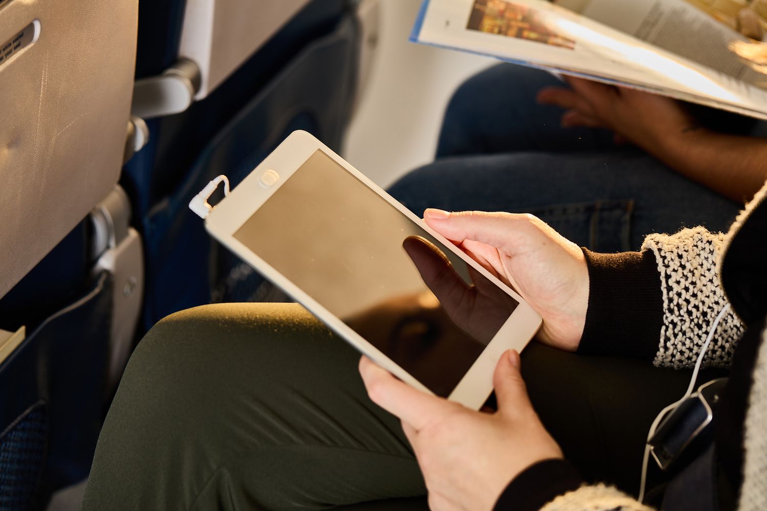A person with a tablet on a flight
