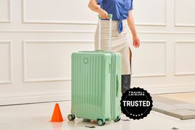 A person rolling the Bric's Positano 27-inch Spinner Suitcase