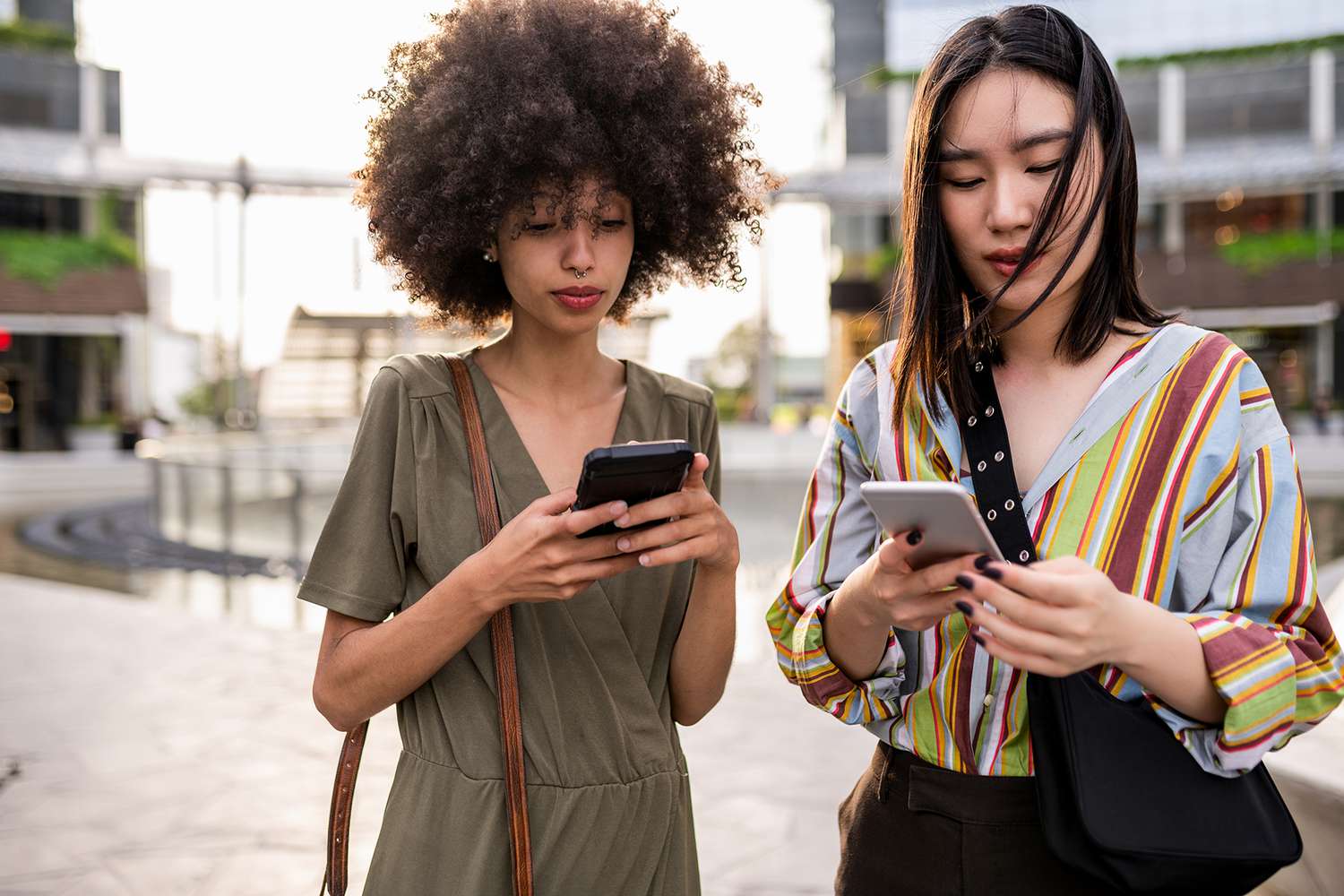 Two women standing on the street and using mobile phone in Italy