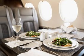 Two salads and a glass of champagne on a Planet 9 private plane 