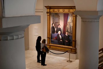 Women pause in front of The Four Justices, a portrait by Nelson Shanks inside the National Portrait Gallery