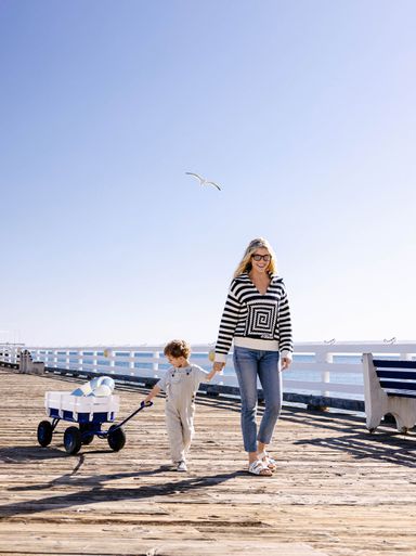 Amanda Kloots and her son Elvis Cordero on the Malibu Pier with a wagon and a bird 