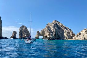 Bright blue skies and water on a sunny day showing the rock formations and archway in Cabo
