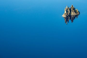 Phantom Ship Reflects In The Blue Waters Of Crater Lake in summer