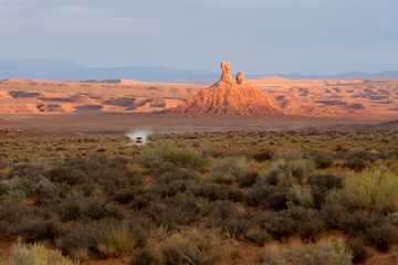 SUV driving through the Valley of the Gods, Utah