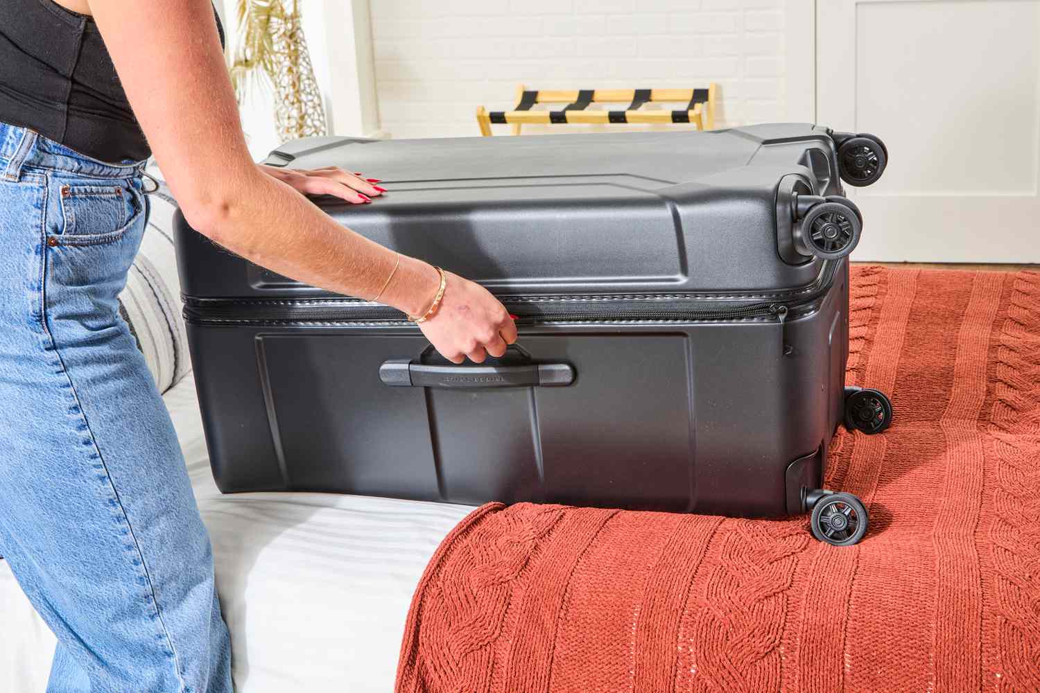 A person closing the Briggs & Riley Extra Large Trunk Spinner