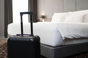 A suitcase placing in front of the bedroom in luxury hotel room