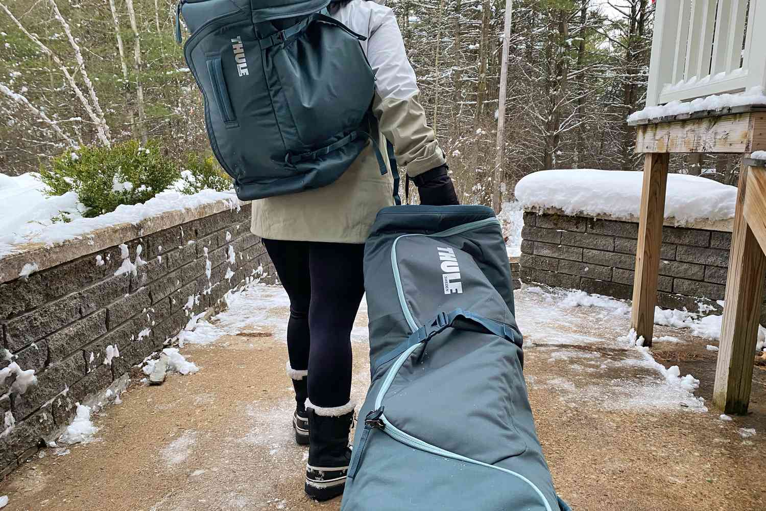 Person carries a Thule RoundTrip Ski Roller Ski Bag outdoors