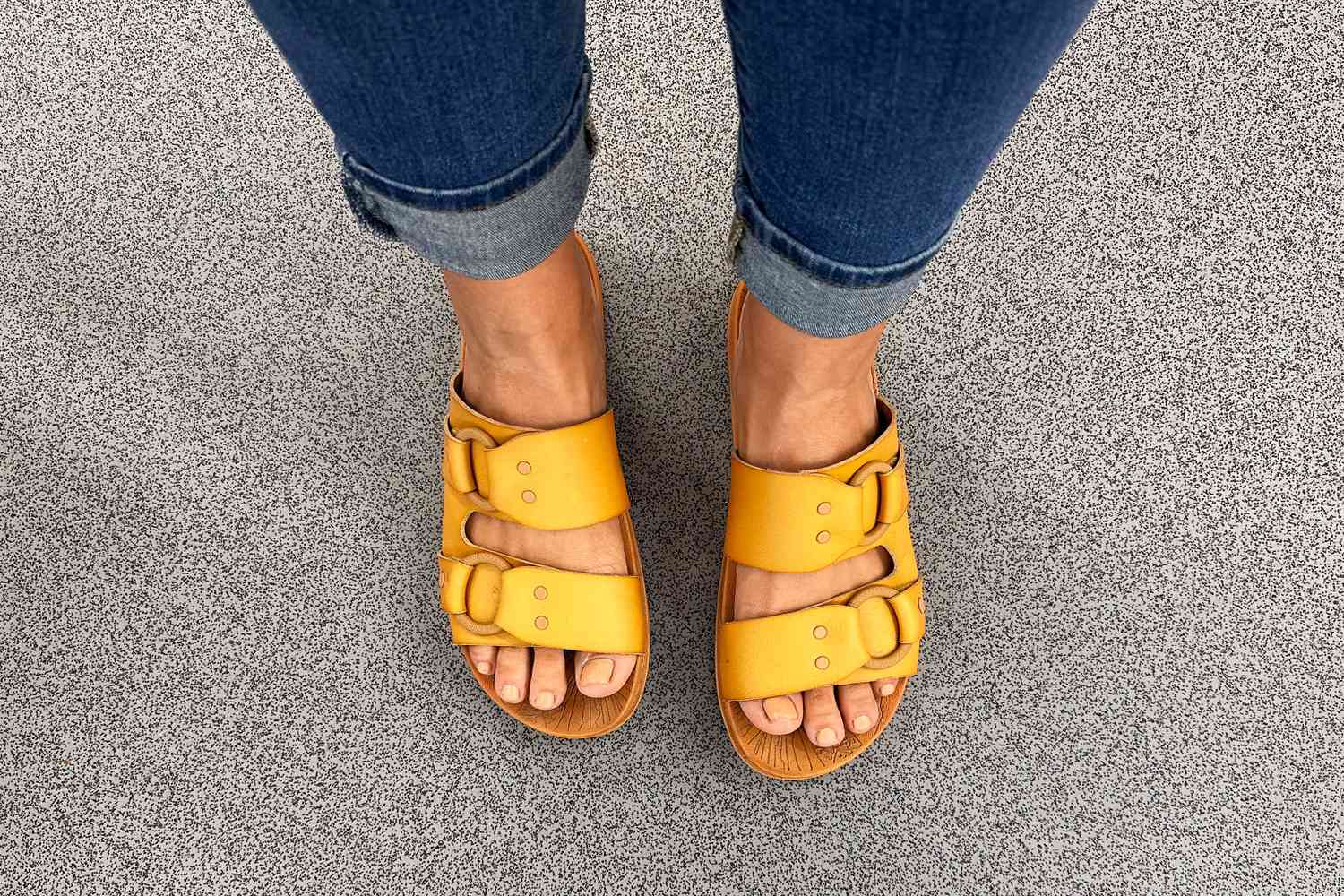 A person wearing the Reef Cushion Vera Cruz Slide on their feet outside.