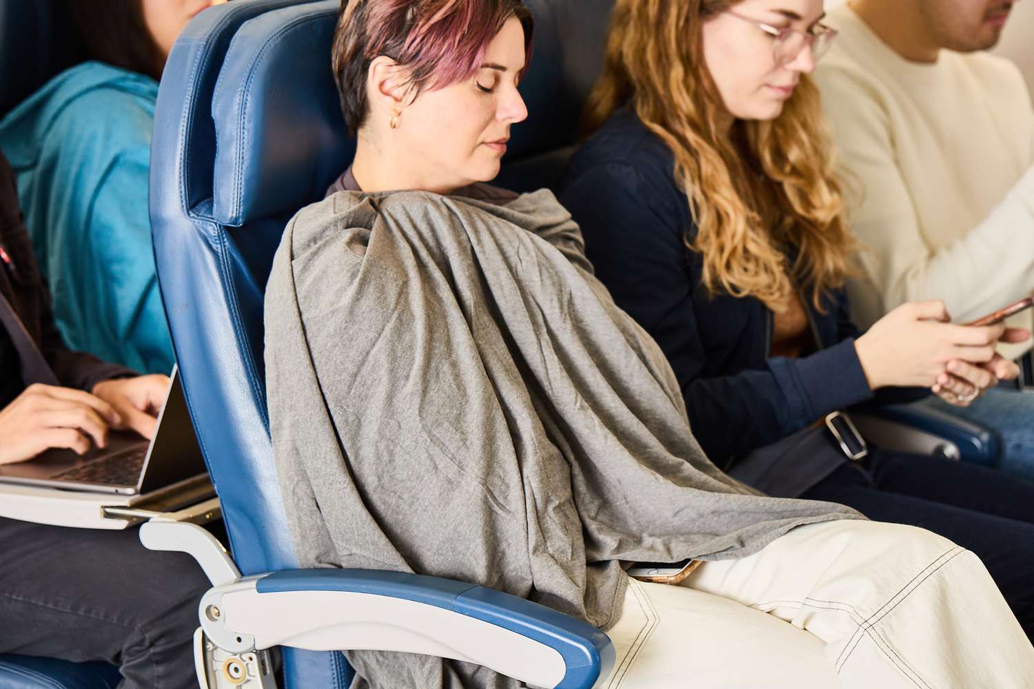 A person sleeping with a travel blanket