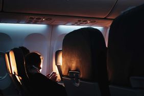 Passenger sleeping in plane with the sun coming in through the windows