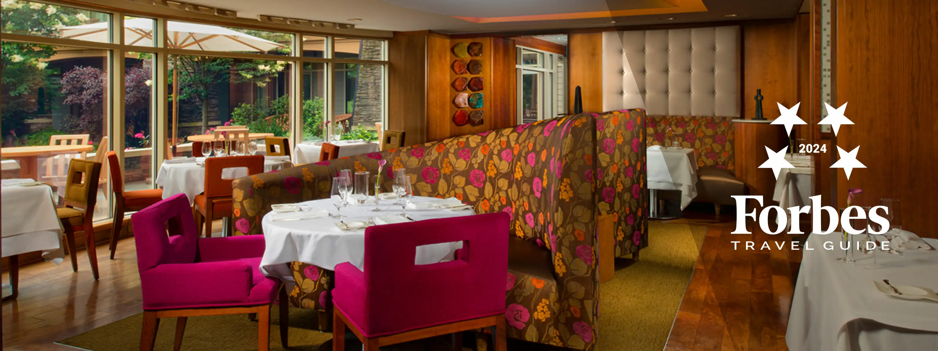 Pink and orange booth seating with a table and pink chairs