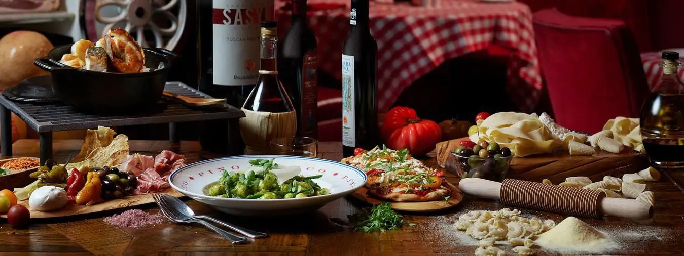 Noodles, pizza, bowl of pasta, and seasoning on a table