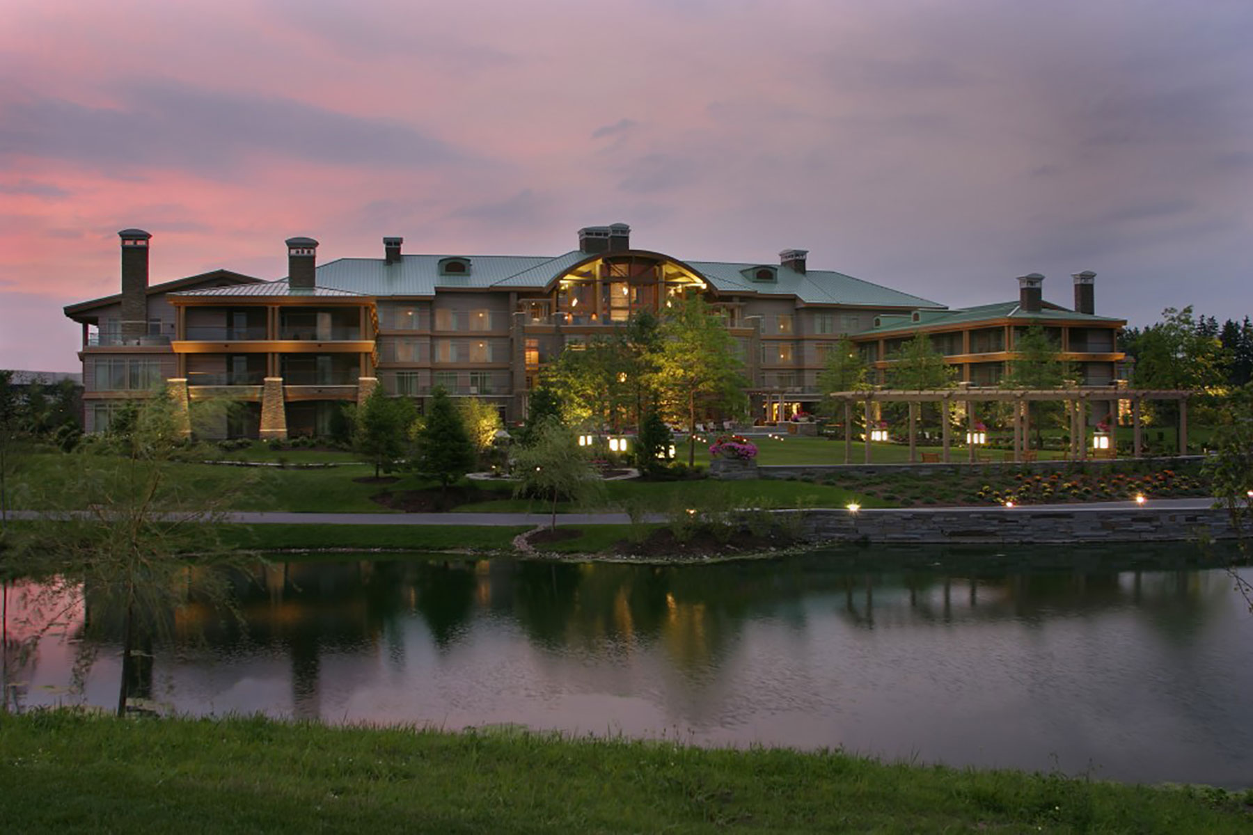 Upstate NY pond at sunset with The Lodge Hotel at Turning Stone in the background being reflected in the water