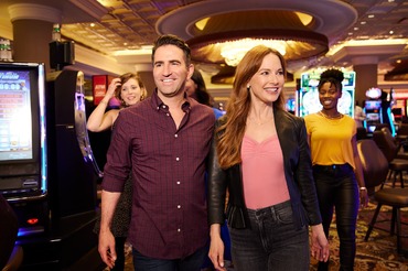 An excited couple walking across a casino gaming floor.