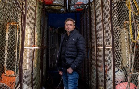 Captian Jake Anderson poses between pots on the deck of the FV Titan Explorer