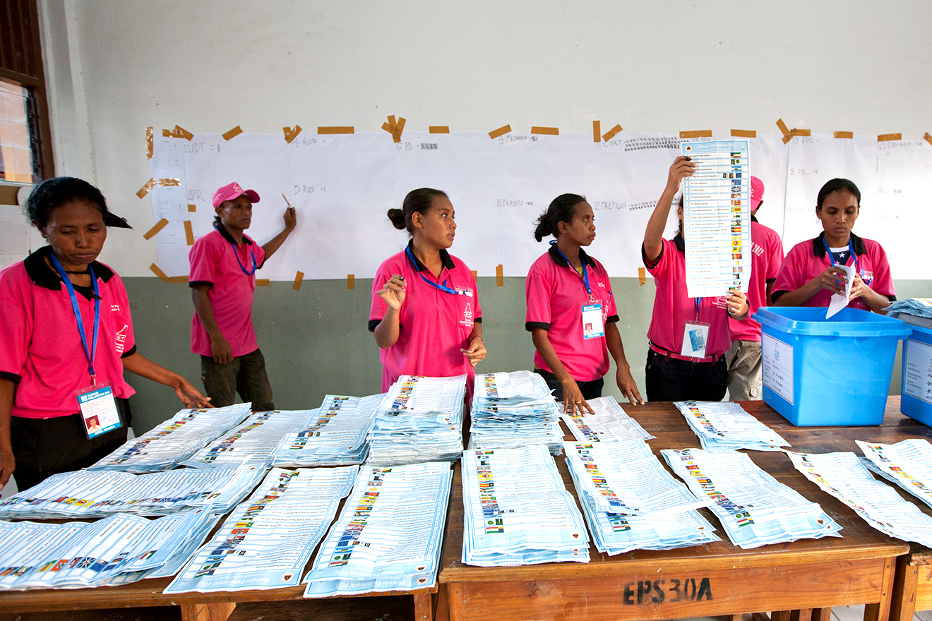 Polling officers tally votes at a polling station after ballots were cast in Timor-Leste's parliamentary elections.