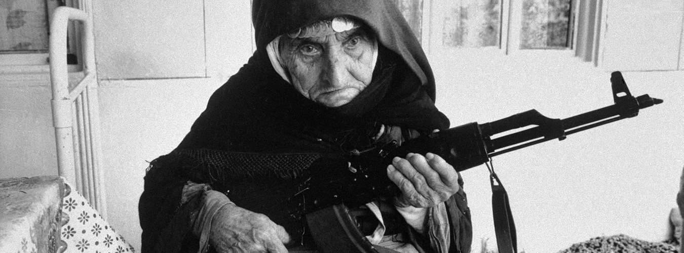 Une femme de 106 ans assise devant sa maison munie d'un fusil dans le village de Degh (Arménie)