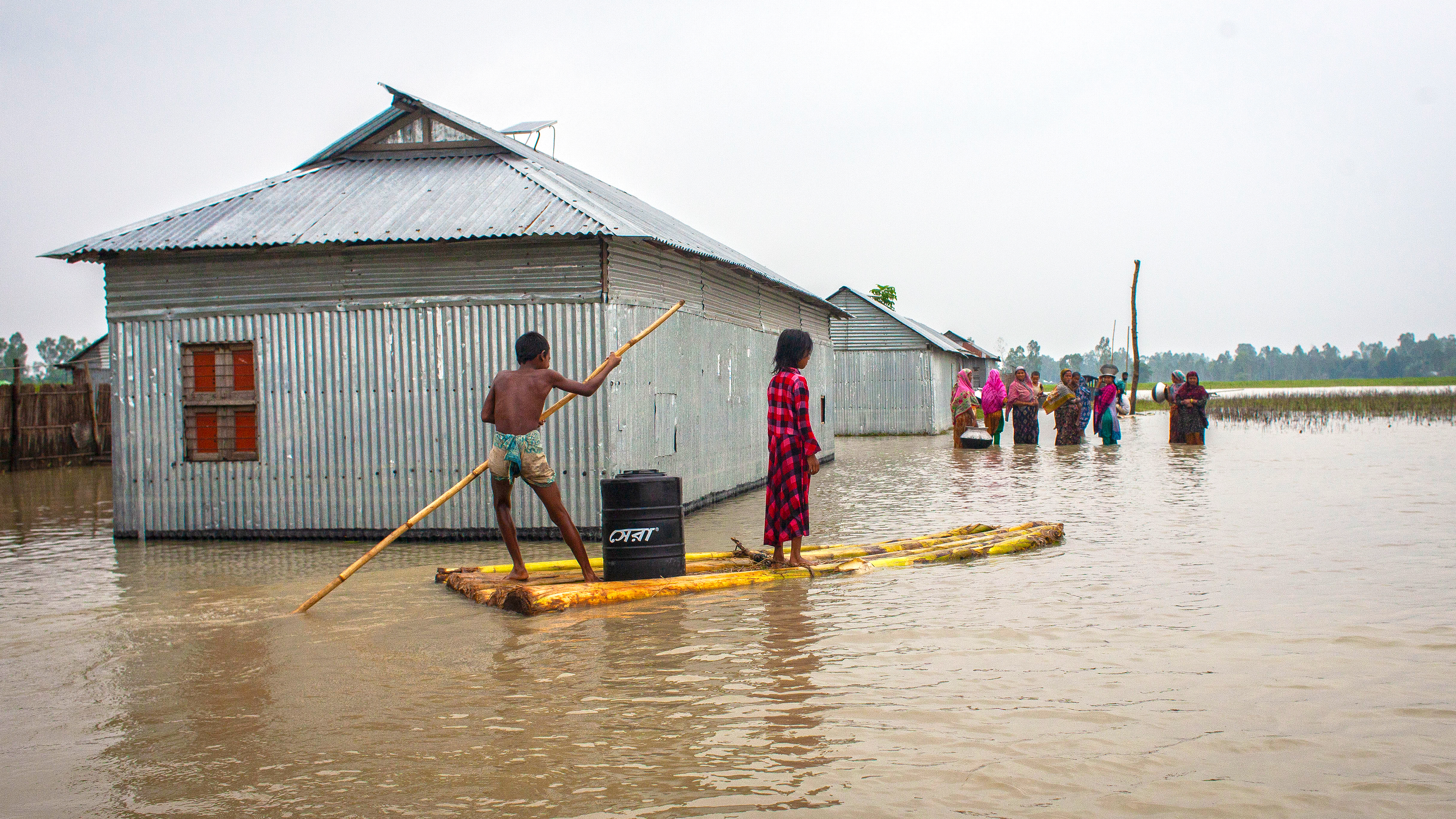 people wading through flood waters