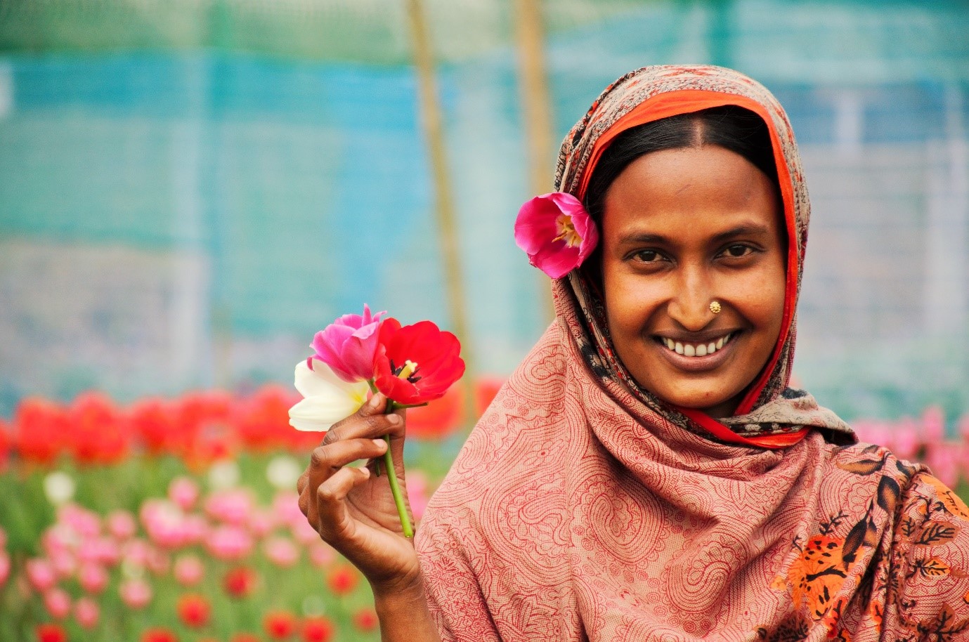 A woman holds up two tulips for her portrait photo