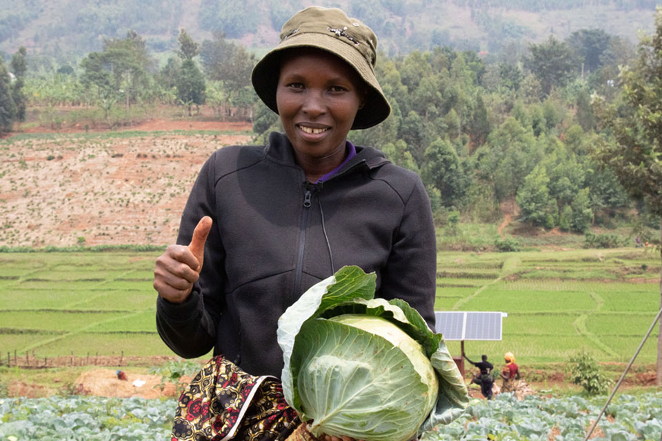 Une agricultrice pose pour une photo avec sa récolte de choux