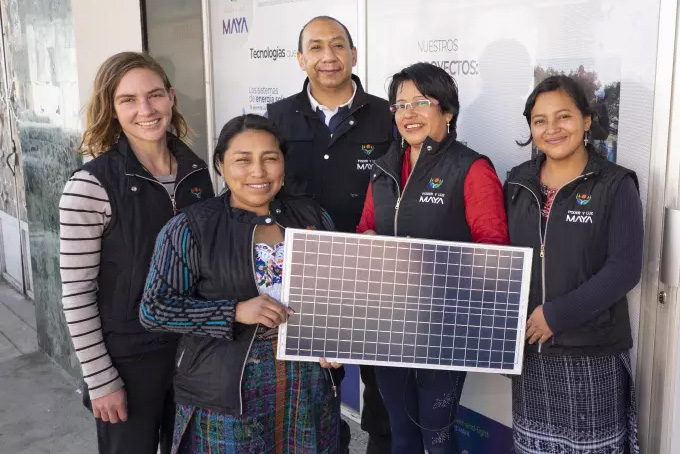 Plusieurs personnes posent avec un panneau solaire