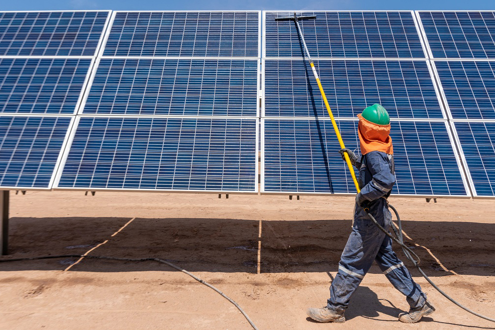 Une personne nettoie des panneaux solaires