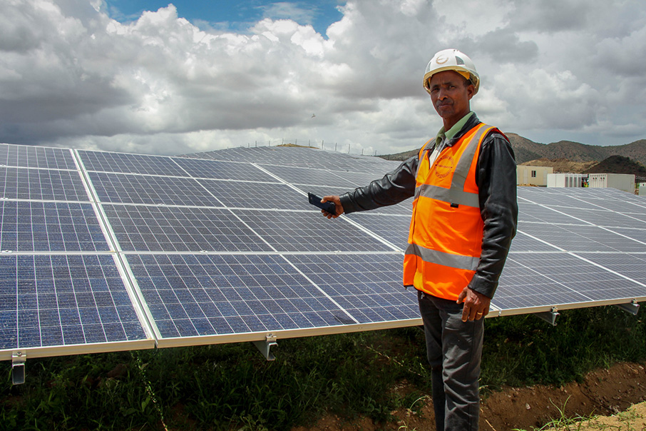 worker in front of solar panels