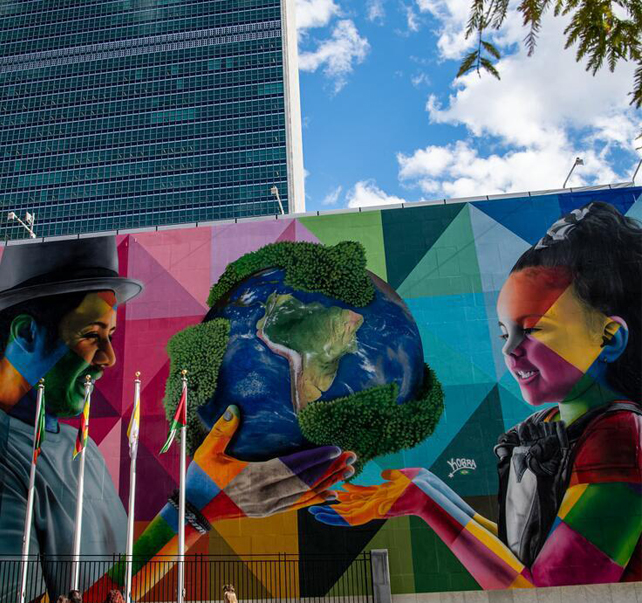 Photo de la fresque d'Eduardo Kobra au Siège de l'ONU représentant un homme offrant un globe à une jeune fille