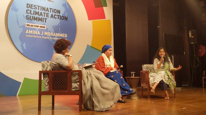 Trois femmes sont assises sur une scène. 