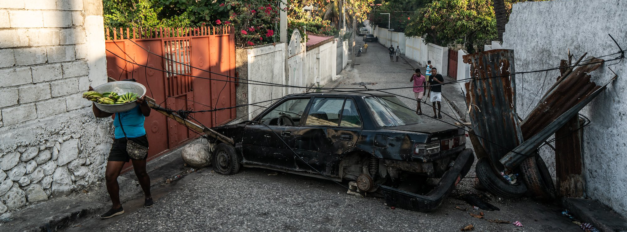 une voiture et des pneus brûlés en travers d'une rue passante