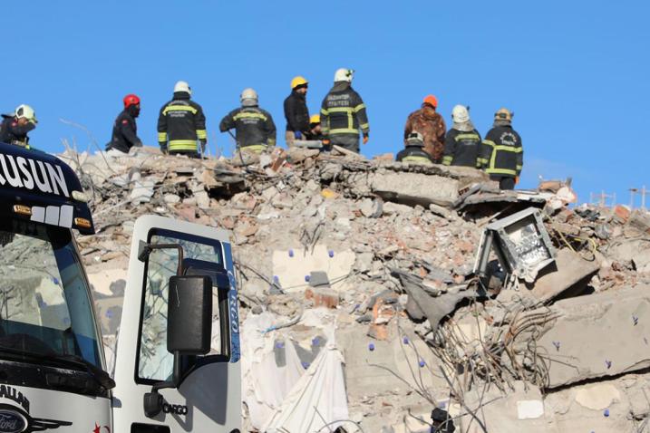 Photo de pompiers sur les décombres, servant de lien vers le site de l'OIM