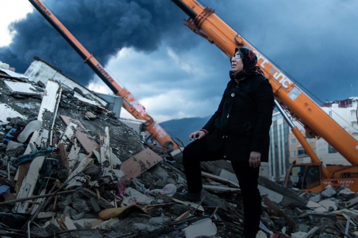 Photo d'une femme regarde les décombres d'un immeuble, servant de lien vers le site de l'OMS