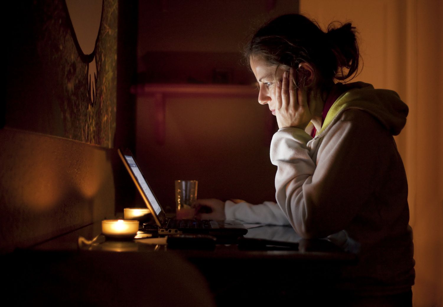 Woman looking at a computer in a darkened room