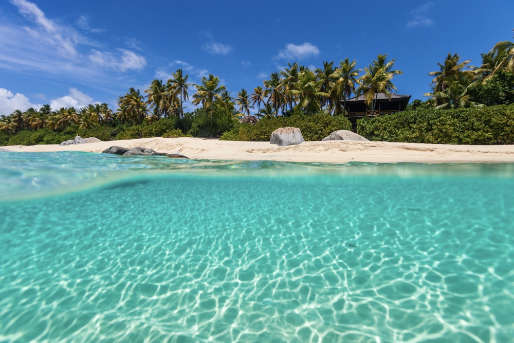 Tropical beach with white sand, turquoise ocean water and blue sky at Virgin Gorda, British Virgin Islands in Caribbean.