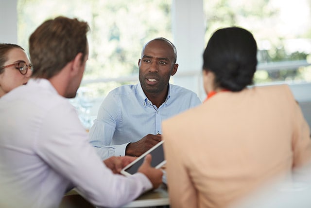 Four people having a discussion in an office setting