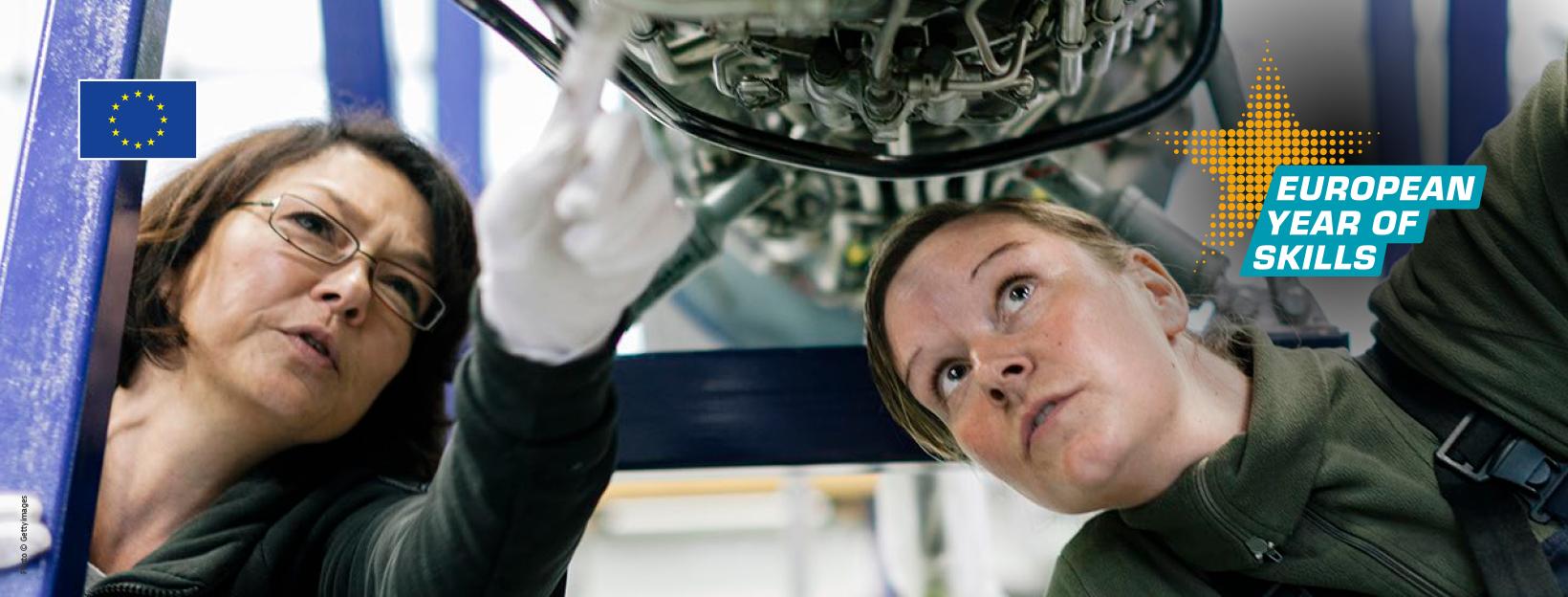 Two women examining a machine